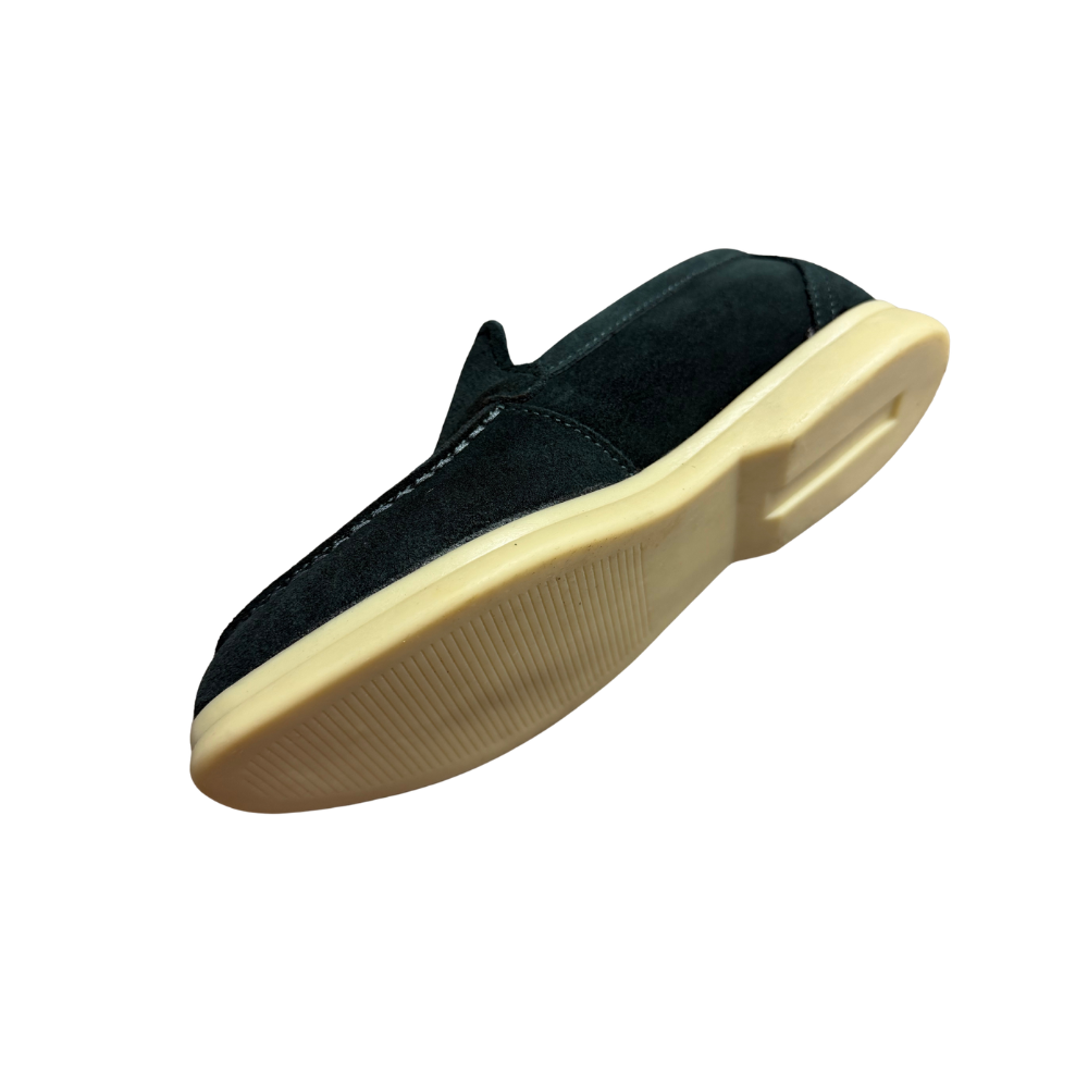 Black slip-on shoe with a beige sole on a white background