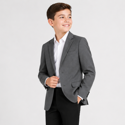 Young boy wearing a gray blazer over a white shirt on a light gray background
