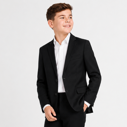 Young boy wearing a black suit jacket and white shirt on a light gray background