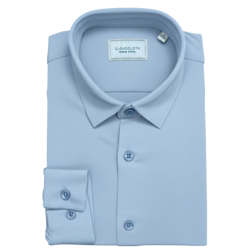 Folded light blue dress shirt with CloudCloth label on a white background
