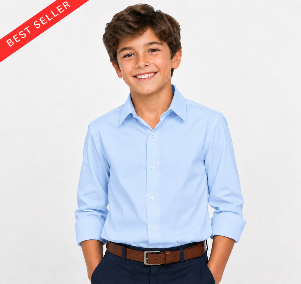 A smiling young boy wearing a light blue long-sleeve button-down dress shirt, dark navy trousers, and a brown belt, posed against a light gray studio background with a red 'BEST SELLER' banner in the top-left corner.