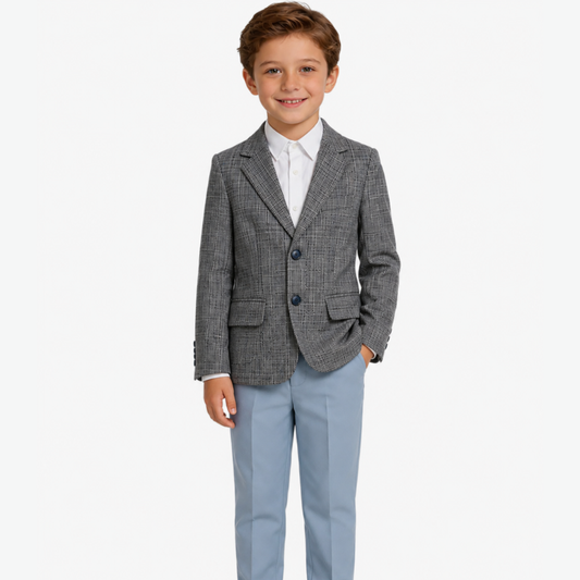 Young boy wearing a gray checkered blazer and light blue pants on a white background