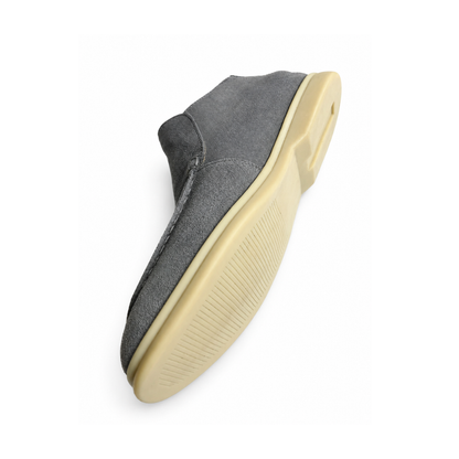 Gray slip-on shoe with a gold sole on a white background