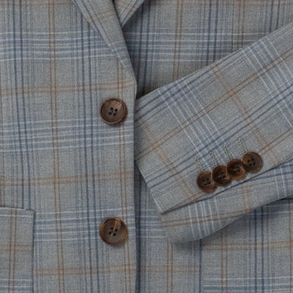 Close-up of a plaid jacket with buttons on a textured fabric background